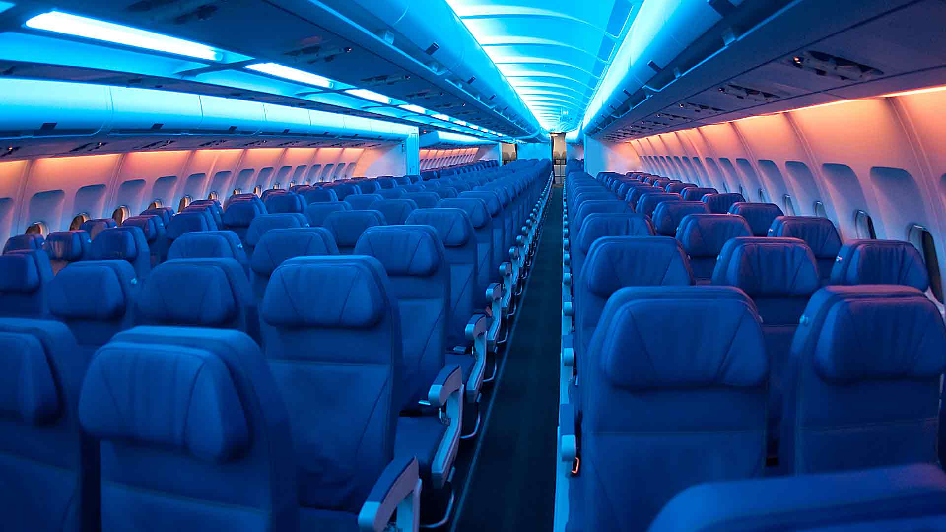 Rows of airplan seats illuminated by blue light